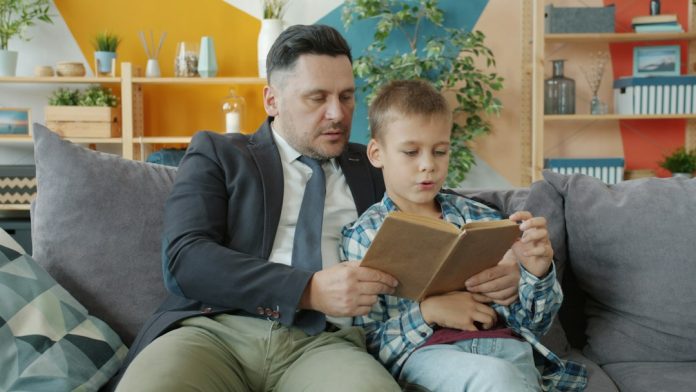 ONE Publisher parenting stock image Parent reading a book with a child at home