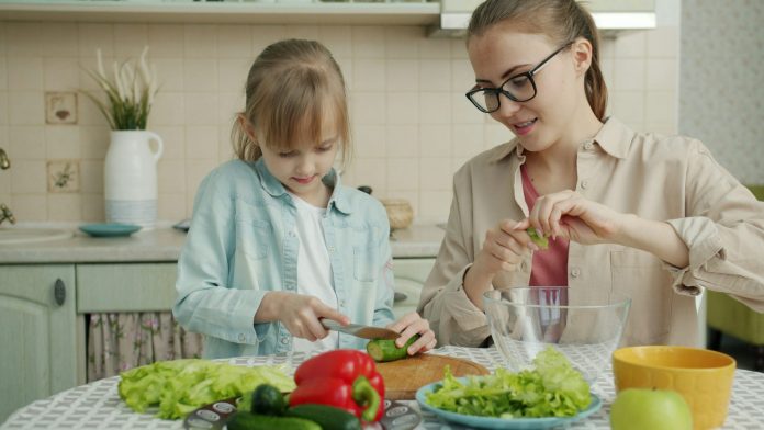 Μητέρα και κόρη ετοιμάζουν μαζί σαλάτα στην κουζίνα